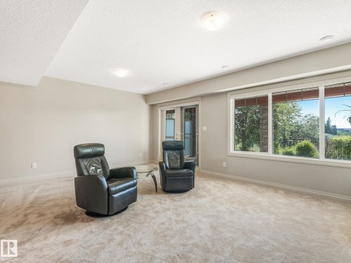 Spacious room featuring multiple large windows and glass French doors, providing abundant natural light - 3 1641 James Mowatt Trail, Edmonton, AB 