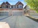 Contemporary exterior featuring multi-toned stucco, stone veneer accents, and gabled rooflines - 3 1641 James Mowatt Trail, Edmonton, AB 