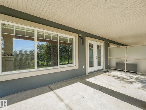 Covered concrete patio with white framed windows and French doors - 3 1641 James Mowatt Trail, Edmonton, AB 
