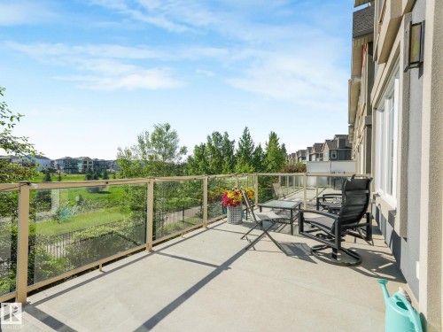 Private concrete patio featuring clear glass railings and exterior lighting - 3 1641 James Mowatt Trail, Edmonton, AB 