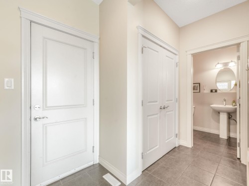 Entryway featuring neutral wall tones, white trim, and dark tile flooring - 3 1641 James Mowatt Trail, Edmonton, AB 