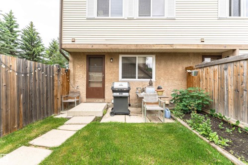 Enclosed backyard featuring a privacy fence, concrete stepping stones, and a cultivated garden bed - 18 Walden Park, St. Albert, AB 