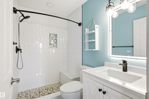 Modern bathroom featuring a walk-in shower with white subway tile, pebble flooring, and a built-in bench - 21384 88 Avenue, Edmonton, AB 