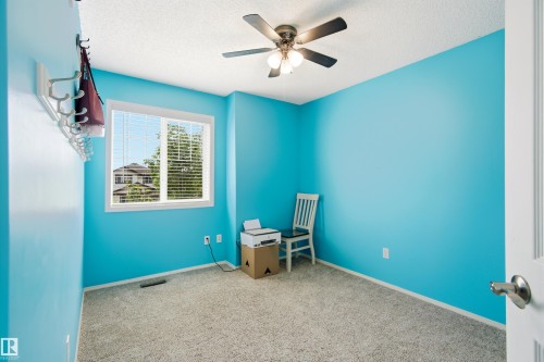 Carpeted room featuring a ceiling fan with light fixture, window with blinds, and white trim - 21384 88 Avenue, Edmonton, AB 
