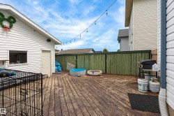 Spacious wood-finish deck with a privacy fence and string lighting - 