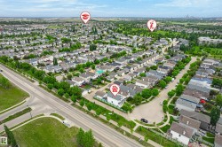 Aerial perspective of a residential neighborhood featuring numerous detached homes with varied rooflines and a network of paved roads - 