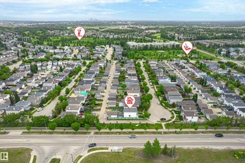Aerial overview of a residential neighborhood with tree-lined streets, single-family homes, and green spaces - 21384 88 Avenue, Edmonton, AB 