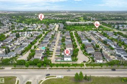 Aerial overview of a residential neighborhood with tree-lined streets, single-family homes, and green spaces - 