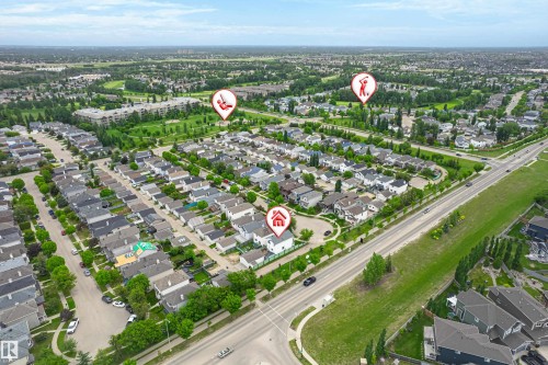 Aerial perspective showcasing a residential neighborhood with tree-lined streets, a golf course, and a commercial corridor - 21384 88 Avenue, Edmonton, AB 
