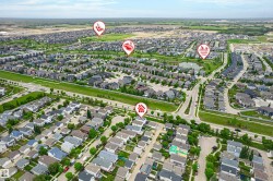 Expansive aerial view of a residential development featuring numerous single-family homes and townhomes - 