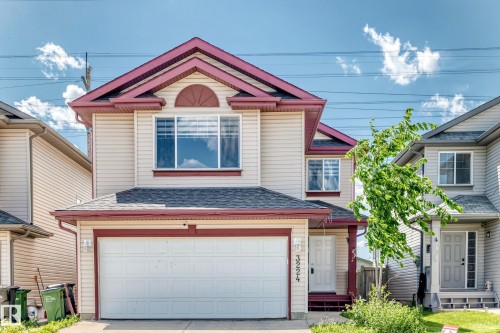Two-story residence featuring light-colored siding with a contrasting deep red trim - 3224 26 Street, Edmonton, AB 