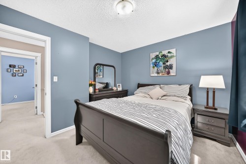 Spacious bedroom with light blue walls and cream-colored carpeting - 3224 26 Street, Edmonton, AB 