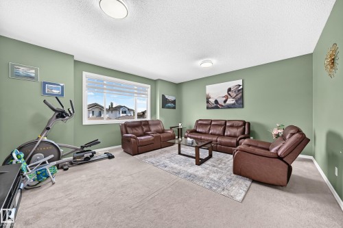 Spacious room featuring light green walls and light-colored carpeting - 3224 26 Street, Edmonton, AB 