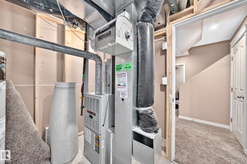 Utility area featuring a furnace, water heater, and exposed ductwork - 3224 26 Street, Edmonton, AB 