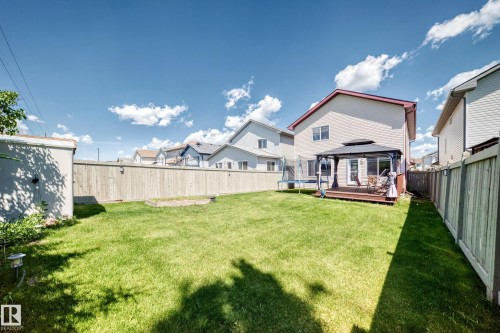Expansive backyard featuring a manicured lawn, full privacy fencing, and a dedicated patio space with a gazebo - 3224 26 Street, Edmonton, AB 
