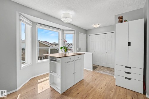 Kitchen area featuring light wood-finish flooring, a central island with a wood-finish countertop, and a bay window configuration - 2123 36 Avenue, Edmonton, AB - Indoor Photo Showing Other Room