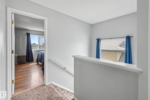 Upper-level landing featuring a carpeted staircase and a window with a sill - 2123 36 Avenue, Edmonton, AB - Indoor Photo Showing Other Room