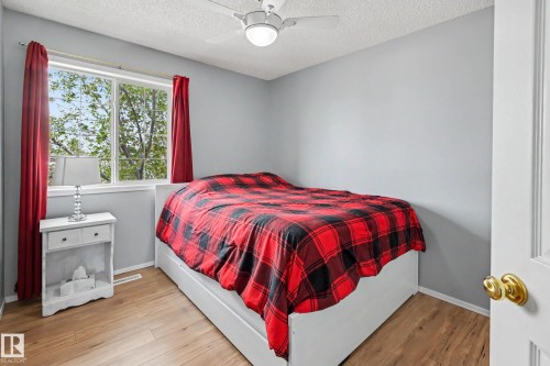 Room featuring wood-finish flooring, a contemporary ceiling fan, and a double-pane window with white trim - 2123 36 Avenue, Edmonton, AB - Indoor Photo Showing Bedroom