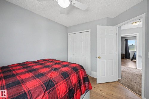 Bedroom featuring wood-finish flooring, a ceiling fan with integrated lighting, and a bi-fold closet - 2123 36 Avenue, Edmonton, AB - Indoor Photo Showing Bedroom