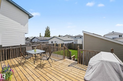 Spacious wood-plank deck with wood railings, leading to a fenced backyard with green lawn - 2123 36 Avenue, Edmonton, AB - Outdoor With Deck Patio Veranda With Exterior