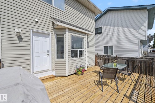 Exterior wood deck with a privacy fence, featuring light gray vinyl siding and a white exterior door - 2123 36 Avenue, Edmonton, AB - Outdoor With Deck Patio Veranda With Exterior