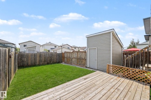 Expansive backyard featuring a wood deck, green lawn, and a storage shed with siding - 2123 36 Avenue, Edmonton, AB - Outdoor With Deck Patio Veranda
