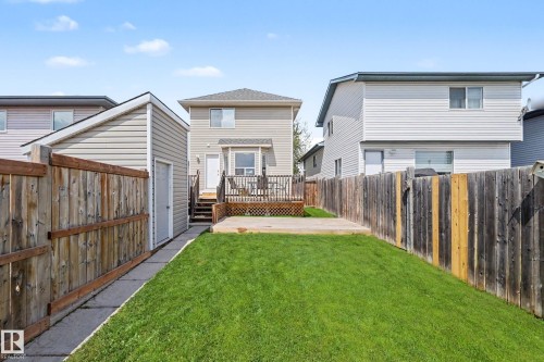Expansive backyard featuring a manicured lawn, concrete patio, and a wood privacy fence - 2123 36 Avenue, Edmonton, AB - Outdoor With Deck Patio Veranda With Exterior