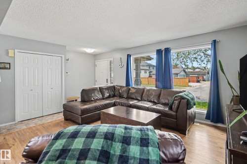 Living area featuring wood-finish flooring, light grey painted walls, and white trim - 2123 36 Avenue, Edmonton, AB - Indoor Photo Showing Living Room
