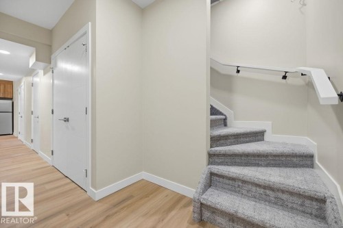 Staircase with gray carpeting and a white handrail - 15004 62 Street, Edmonton, AB 