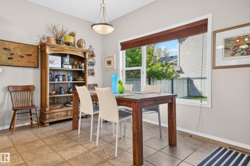 Dining area featuring large window, ceramic tile flooring, neutral wall tones, and overhead lighting - 1310 82 Street, Edmonton, AB 