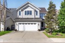 Two-story residence featuring light gray siding, a prominent front gable, and a two-car garage with paneling - 1310 82 Street, Edmonton, AB 