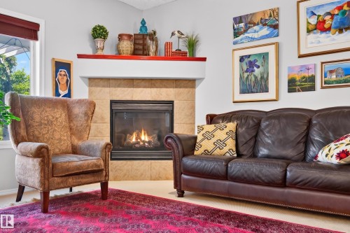 Living area featuring a gas fireplace with a tiled surround and a white mantle with a red trim - 1310 82 Street, Edmonton, AB 