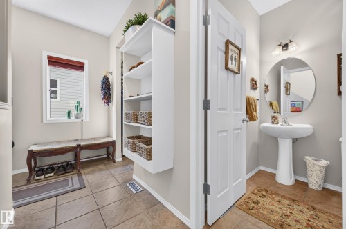 Pedestal sink with a circular mirror and overhead two-light vanity fixture - 1310 82 Street, Edmonton, AB 