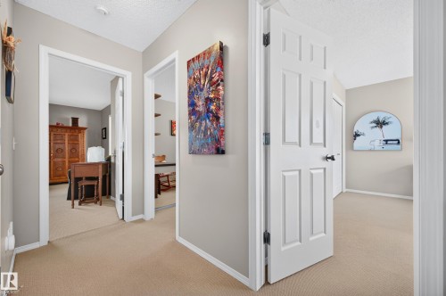 Interior hallway featuring neutral wall paint, carpet flooring, white trim, and white paneled doors - 1310 82 Street, Edmonton, AB 