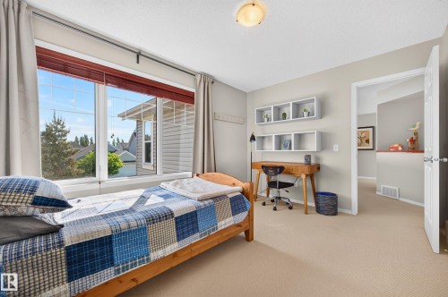 Bright room featuring a large multi-pane window with horizontal blinds, neutral carpeting, and light-toned walls - 1310 82 Street, Edmonton, AB 