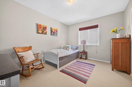 Light-filled room featuring wall-to-wall carpeting, neutral wall tones, and a window with white blinds and a valance - 1310 82 Street, Edmonton, AB 