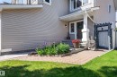 Front entrance featuring a covered porch with a substantial white column, light brown siding, and a paver walkway - 1310 82 Street, Edmonton, AB 