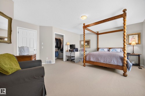 Carpeted bedroom featuring neutral paint, a standard door, a closet opening, and overhead lighting - 1310 82 Street, Edmonton, AB 