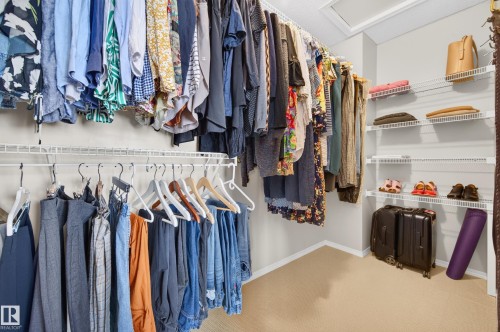 Spacious walk-in closet featuring wire shelving and multiple hanging rods for ample storage - 1310 82 Street, Edmonton, AB 