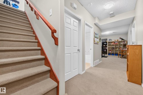 Carpeted staircase with a wood handrail - 1310 82 Street, Edmonton, AB 