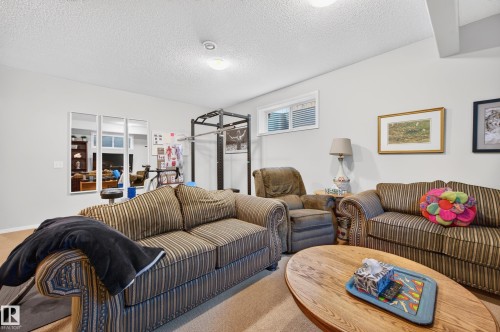 Spacious room featuring light gray walls, recessed lighting, and a textured ceiling - 1310 82 Street, Edmonton, AB 