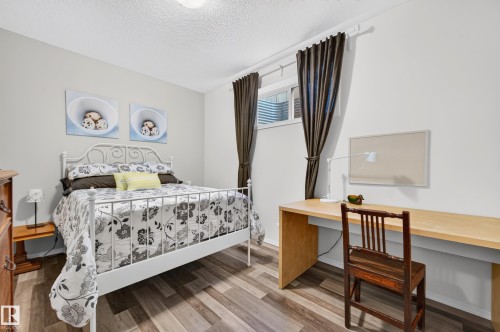 Recessed window featuring dark drapery, wood-finish flooring, and white painted walls - 1310 82 Street, Edmonton, AB 