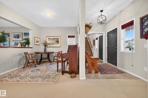 Split-level entry foyer featuring tile flooring, a dark paneled door, and a globe pendant light fixture - 1310 82 Street, Edmonton, AB 