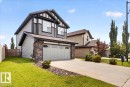 Two-story residence featuring a two-car garage with overhead lighting, stone detailing, and a concrete driveway - 17203 71 Street, Edmonton, AB 