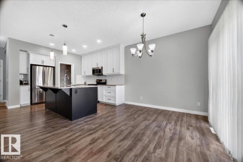 Open-concept kitchen and dining area featuring wood-finish flooring - 17203 71 Street, Edmonton, AB 