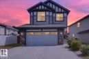 Two-story residence featuring a two-car garage with a paneled door, stone accents on the facade, and a concrete driveway - 17203 71 Street, Edmonton, AB 
