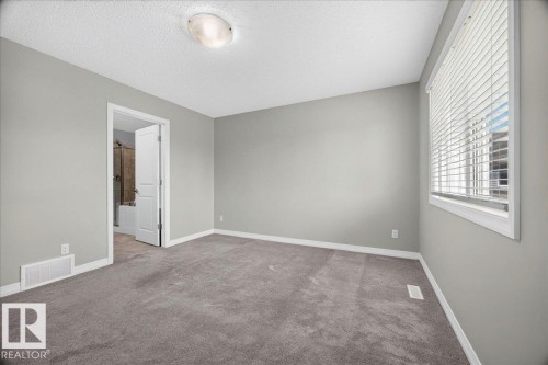 Spacious room with plush gray carpeting, neutral gray walls, and white trim - 17203 71 Street, Edmonton, AB 