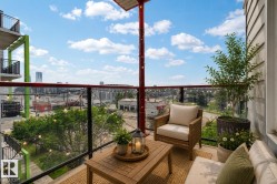 Balcony featuring a glass railing, wood-finish flooring, and a red support beam - 