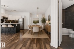 Open-concept living area featuring wood-finish flooring throughout - 