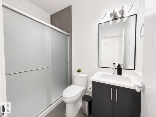 Bathroom featuring a modern vanity with a white countertop, rectangular undermount sink, and dark gray cabinetry - 415 42 Street, Edmonton, AB 